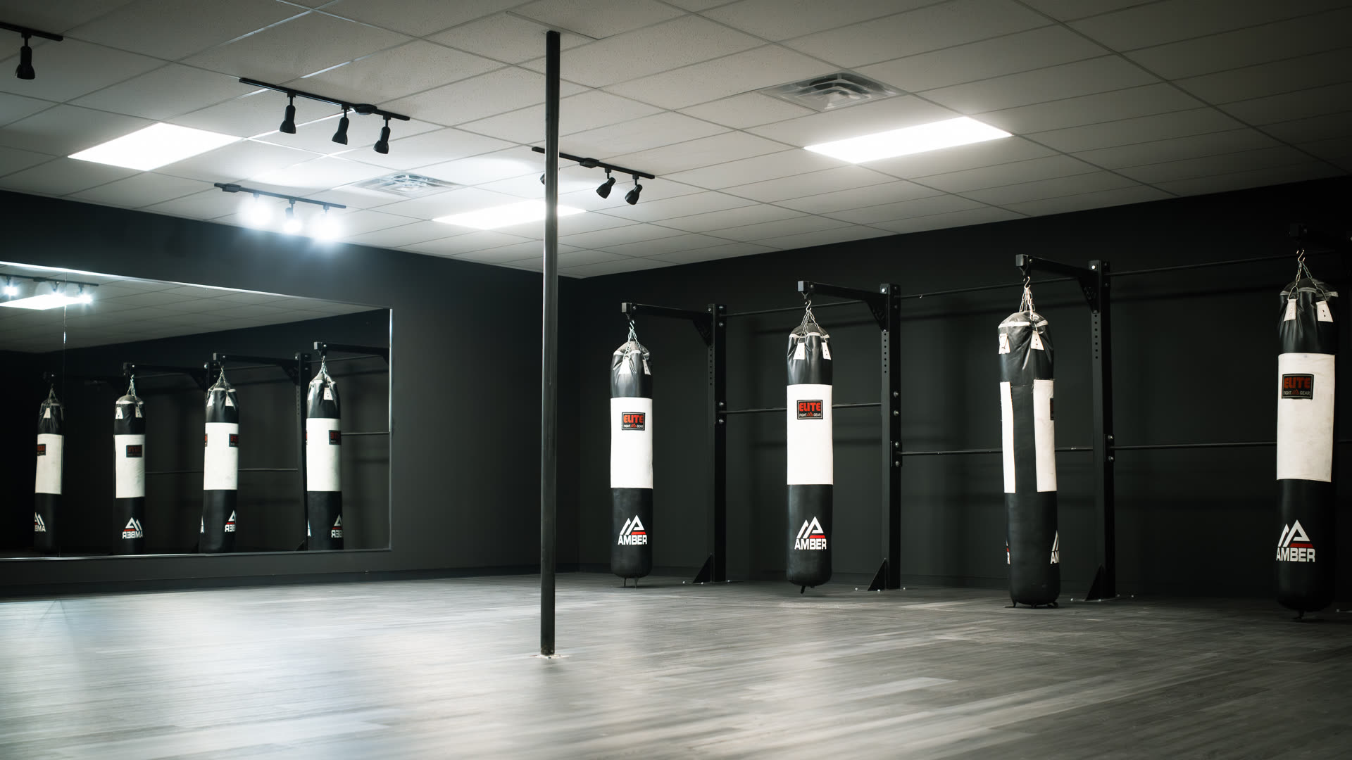 Open studio floor with mirrors and heavy bags